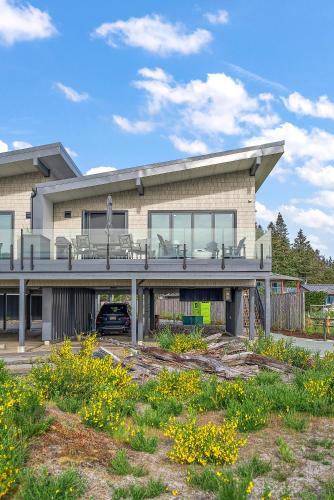 a large house with a balcony and a yard at Beachfront Villa #14 at The Beach House in Campbell River