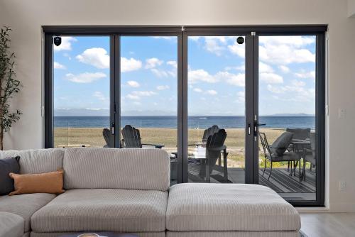 a living room with a couch and a view of the ocean at Beachfront Villa #14 at The Beach House in Campbell River