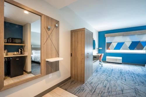 a room with a sliding door and a bedroom at Holiday Inn Express & Suites Charlottesville by IHG in Charlottesville