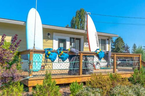 a house with two surfboards on the front porch at Coastal Haven at THE BEACH HOUSE in Campbell River