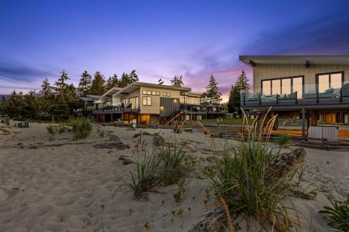 a large house on the beach with a building at Coastal Haven at THE BEACH HOUSE in Campbell River