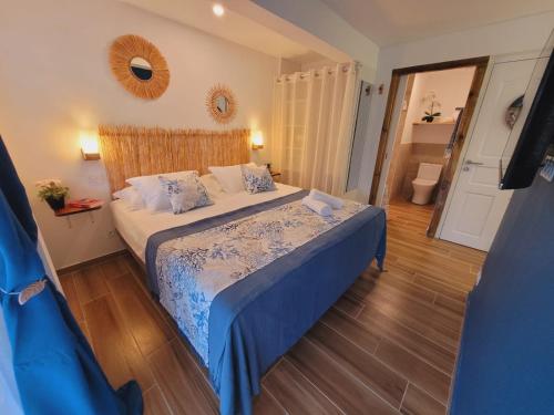 a bedroom with a bed with a blue comforter at MY SWEET HOME Location - Feel Unique, Stay Unique in Faaa