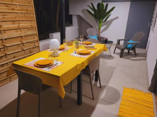 a dining room with a yellow table and chairs at MY SWEET HOME Location - Feel Unique, Stay Unique in Faaa