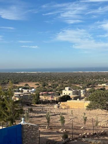 a view of a city with houses and the ocean at Dar Edouard in Sidi Kaouki