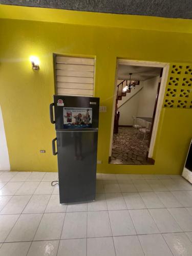 a refrigerator in a room with a yellow wall at Cozy Family Inn in Port Antonio