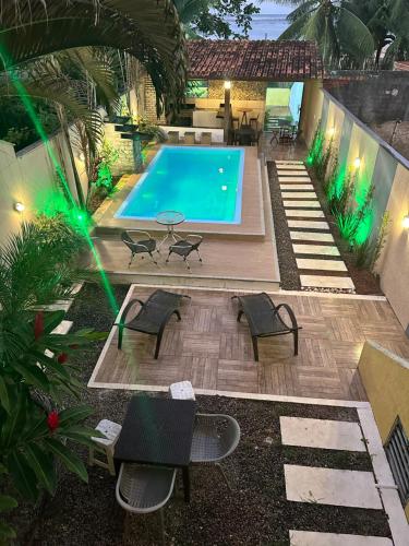 an overhead view of a swimming pool with chairs and a table at Residência Wimbledon in Ilhéus