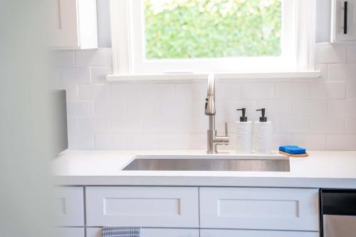 a white kitchen with a sink and a window at Spacious 5B2B home 5 min to airport with AC, Game Room, WiFi, Parking in SeaTac