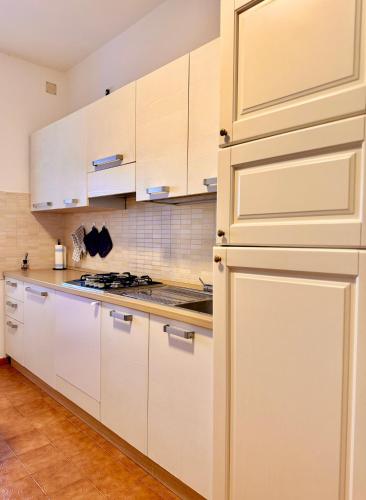 a kitchen with white cabinets and a stove at Blue Terrace Guest House in Alghero