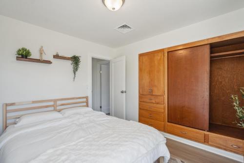 a bedroom with a bed and a large wooden cabinet at Spacious 5B2B home 5 min to airport with AC, Game Room, WiFi, Parking in SeaTac