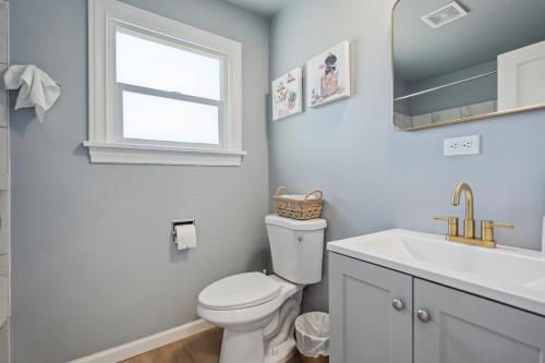 a bathroom with a toilet and a sink and a window at Spacious 5B2B home 5 min to airport with AC, Game Room, WiFi, Parking in SeaTac
