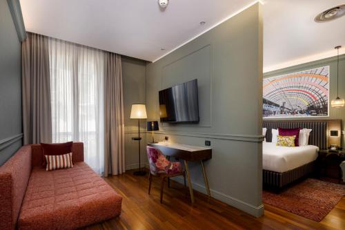 a hotel room with a bed and a desk at Hotel Indigo Turin by IHG in Turin