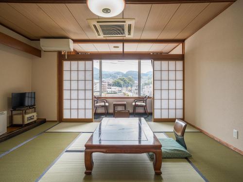 a room with a table and chairs and a room with a window at Irifuneso in Ureshino