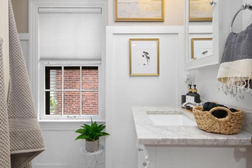 a white bathroom with a sink and a window at The Knocking Bird- Mins to CLE Clinic in Cleveland Heights