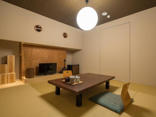 a living room with a table and a tv at Irifuneso in Ureshino
