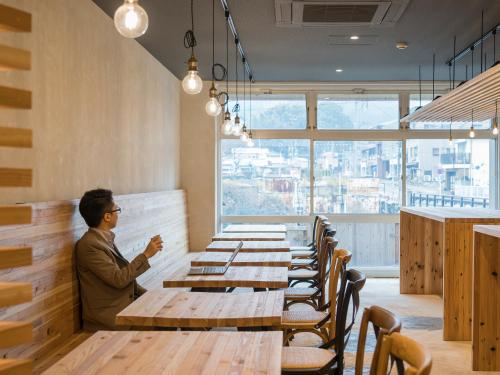 a man sitting at a long table in a restaurant at Irifuneso in Ureshino