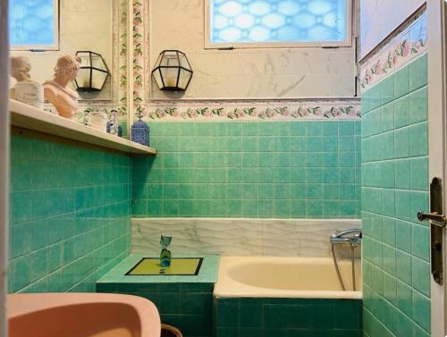 La salle de bains est pourvue de carrelage vert, d'une baignoire et d'un lavabo. dans l'établissement Somptuous exotic villa in Cannes, à Cannes