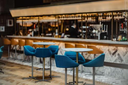 a bar with blue chairs and tables in a room at Radisson Blu Hotel, Glasgow in Glasgow