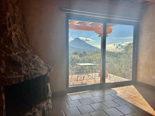 a door to a balcony with a view of a mountain at Le Suisse Spa in Santa Lucía Milpas Altas