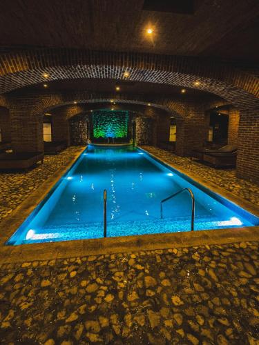 a swimming pool with blue lights in a building at Le Suisse Spa in Santa Lucía Milpas Altas