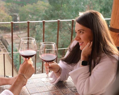 a woman holding up two glasses of wine at Le Suisse Spa in Santa Lucía Milpas Altas