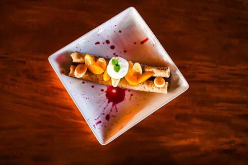 a white plate with a piece of food on a table at Le Suisse Spa in Santa Lucía Milpas Altas