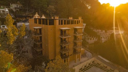 an aerial view of a building with the sun setting at Le Suisse Spa in Santa Lucía Milpas Altas