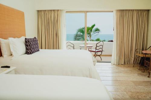 a hotel room with a bed and a view of the ocean at Camino Real Zaashila Huatulco in Santa Cruz Huatulco