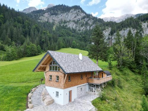 a house on a hill with mountains in the background at Haus 1683 - Wolfbauer in Johnsbach