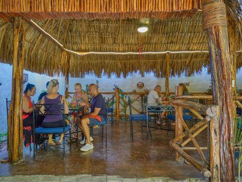 a group of people sitting at a table in a restaurant at Casa Del Maya Bed & Breakfast in Mérida