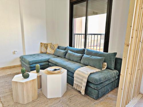 a living room with a blue couch and a table at Ático De Diseño en Aguilas in Águilas