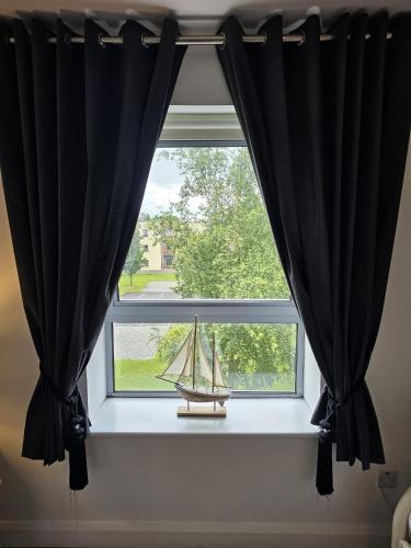 a window with a small boat in a window sill at Wild Atlantic Apartments Killarney in Killarney
