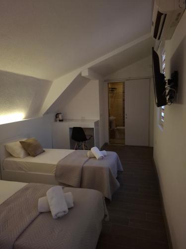 a hotel room with two beds and a television at Z&G Apartment in Bitola