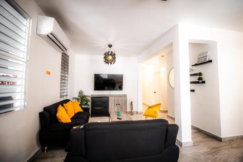 a living room with a black couch and yellow pillows at Entire Vacation Home in San Juan - Fits 10 in San Juan