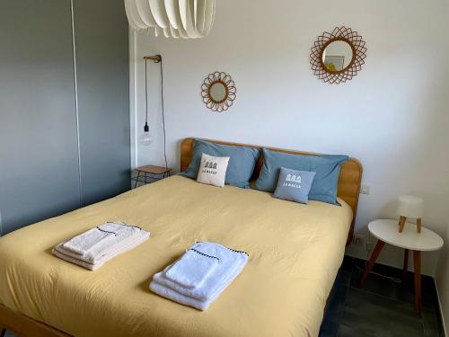 une chambre avec un lit avec deux serviettes dessus dans l'établissement Au Renard Baulois - chambre d'hôtes, à La Baule