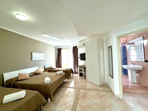 a hotel room with two beds and a sink at B&B Blue in Terrasini