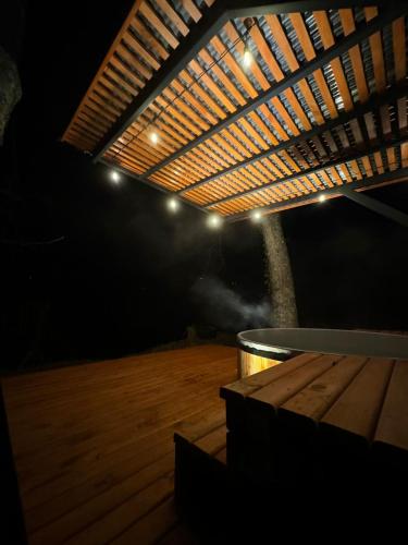 un patio con un tavolo e un pavimento in legno con luci di Domos Elohim a Pucón