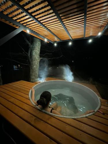 una persona in una vasca da bagno in aysicalysicalysicalysicalysicalysicalysical di Domos Elohim a Pucón