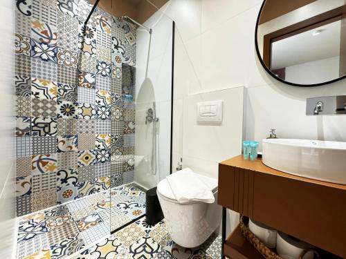 a bathroom with a shower and a sink and a mirror at Villa Noem in Tirana