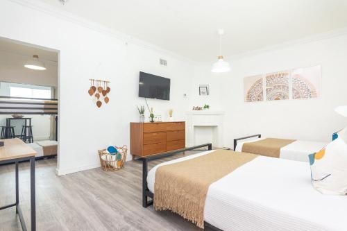 a bedroom with a bed and a desk and a tv at West Deco in Miami Beach