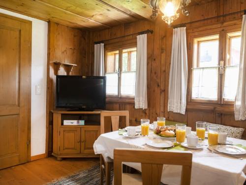 une salle à manger avec une table et une télévision dans l'établissement Sixhäusl, à Kirchberg in Tirol