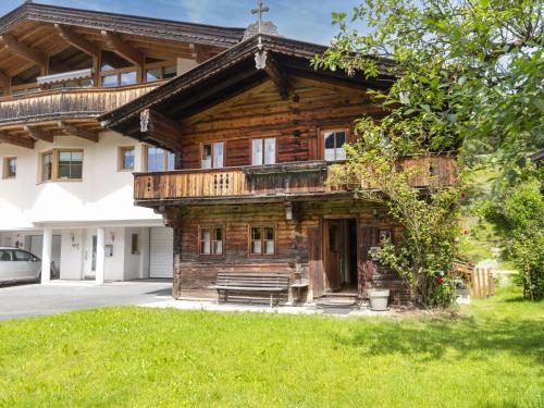 une maison en rondins avec un porche et un banc dans l'établissement Sixhäusl, à Kirchberg in Tirol