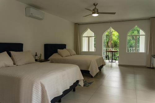a bedroom with two beds and a ceiling fan at Hotel Marjaba in Cuernavaca