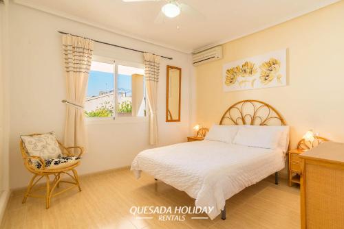 a bedroom with a bed and a window and a chair at Stunning Central Villa Rosa in Ciudad Quesada Rojales Spacious 4-Bedroom Retreat with Private Pool in Ciudad Quesada