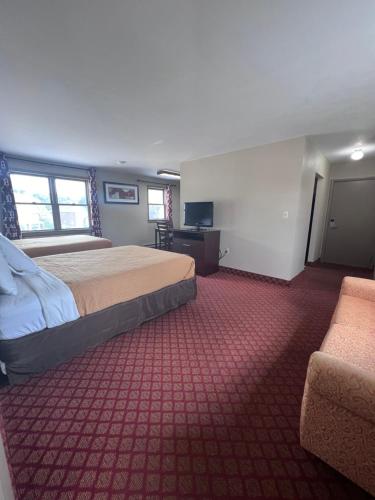 a hotel room with a bed and a couch at Rodeway Inn & Suites Hershey Chocolate Avenue in Hershey