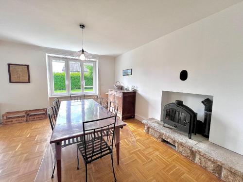 une salle à manger avec une table et une cheminée dans l'établissement Sublime maison familiale refaite à neuf Quartier très calme verdoyant, à Plobannalec-Lesconil