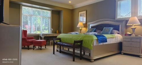 a bedroom with a bed and a desk and a chair at Sunny Island by White Rock B&B in White Rock