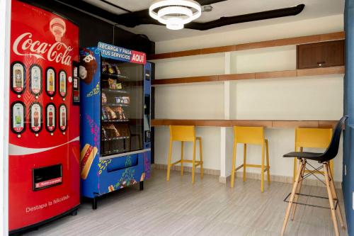 a cocacola soda machine in a room with chairs at New Acapulco Retreat Garden Pool & Gym in Acapulco
