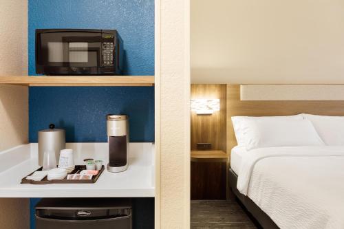 a hotel room with a bed and a microwave at Holiday Inn Express Williamston by IHG in Williamston