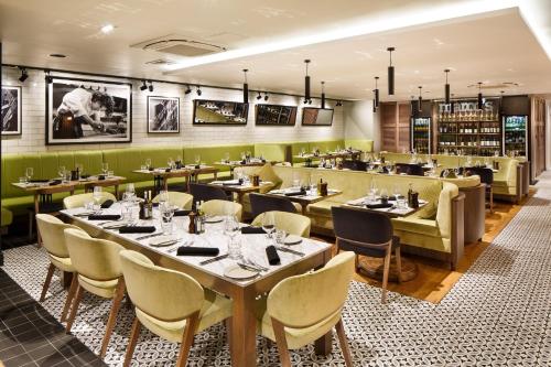 a restaurant with tables and chairs and a bar at Holiday Inn Brentwood by IHG in Brentwood