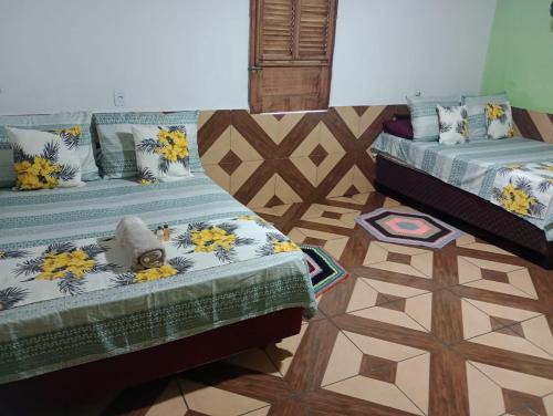 ein Schlafzimmer mit 2 Betten und einem Teddybär oben drauf in der Unterkunft Casa Gael (Gisele & Lucimar) in Atins